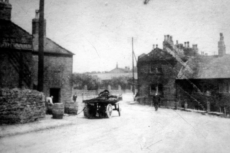 Bruntcliffe Lane circa 1900 showing the Dartmouth Arms on the left, where beer barrels are in the process of being unloaded from a horse-drawn cart. The pub was demolished around 1945. Victoria Road is seen in the distance.