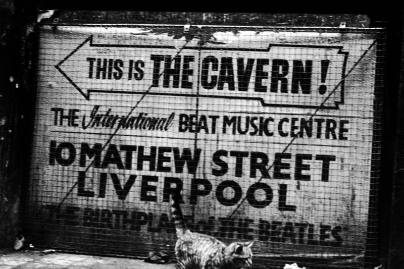 A cat walks past a sign pointing the way to the Cavern Club,' birthplace' of the Beatles in Liverpool, circa 1969.