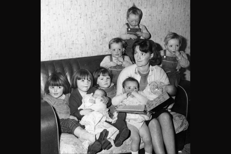 Mary Brocks, 25-year-old mother of nine, including triplets and twins, reading the children a bedtime story in 1963.