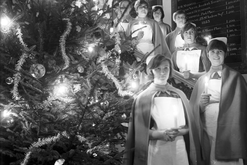 Nurses at the Royal Infirmary in Edinburgh singing Christmas carols in December 1967 with the boards showing donations in the background