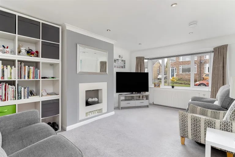 The front facing lounge with pebble-effect gas fire and storage cupboards.