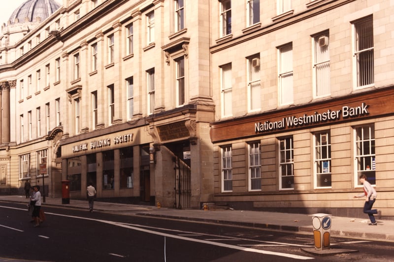 A view of Market Street Newcastle upon Tyne taken in 1983. The photograph shows the Central Exchange Buildings on the right-hand side of Market Street. 'National Westminster Bank' and the 'Halifax Building Society' are on the ground floor of the Central Exchange Buildings. One of the domes of the Central Exchange Buildings can be seen to the left. 