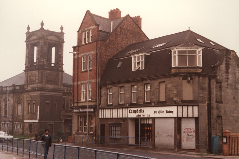 A view of Elswick Road Elswick taken in 1983. The photograph shows a row of buildings on one side of Elswick Road. The derelict John Knox Presbyterian Church is to the left then Beech Grove Road. National Westminster Bank and Campbells baker's shop are on the next block. 
