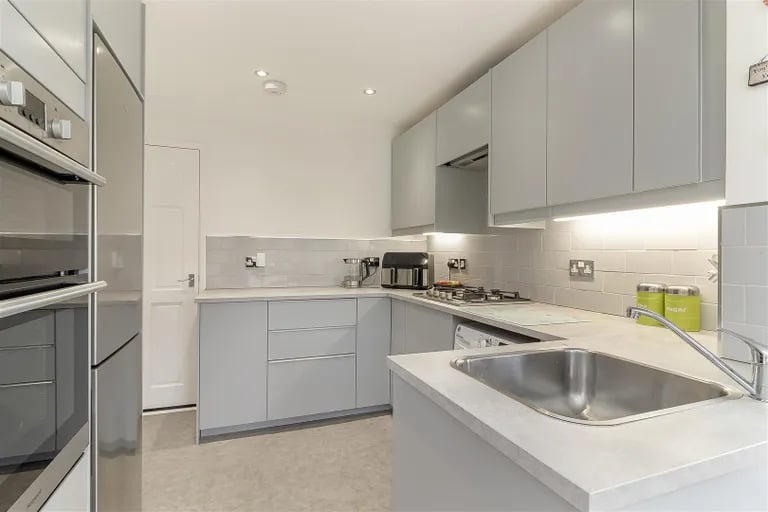 The modern kitchen is fitted with base and wall units and opens to the conservatory.