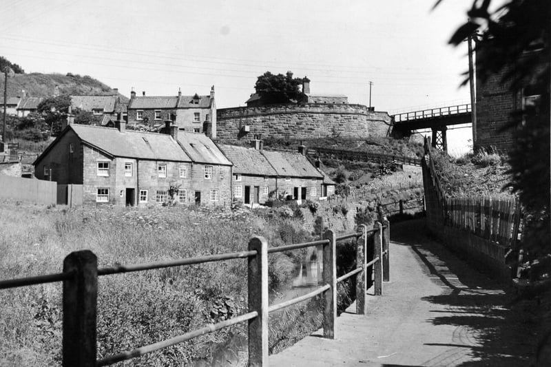 Cottages at the foot of Lythe Bank in July 1949. The railway viaduct and railway station can be seen.