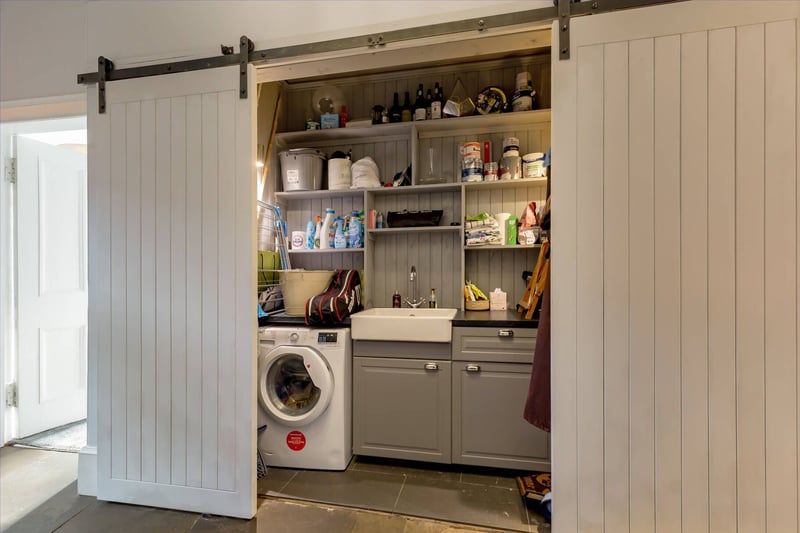 Another clever feature of the property is the utility space which has been created and discreetly concealed by two sliding barn doors. This ideal space is fitted with a traditional pulley, storage cupboards, shelving, sink unit and has plumbing for an automatic washing machine.