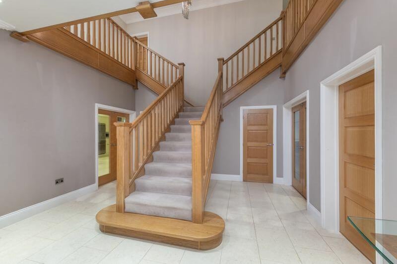 The property's stunning entrance hall provides a warm welcome to the family home.
