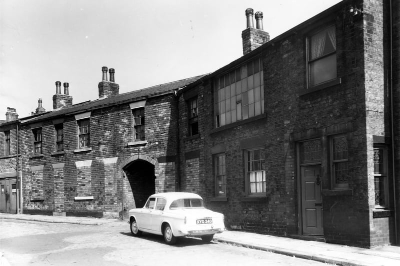 Brick built properties on West End Terrace in August 1961. On the left are numbers 26 and 27, both with bricked up doors and windows. Moving right is a passageway leading to back entrances to shops on Woodhouse Street. Number 28 follows then number 29 which was part of Bittenden's photographers. On the first floor is a large window possibly lighting a studio.