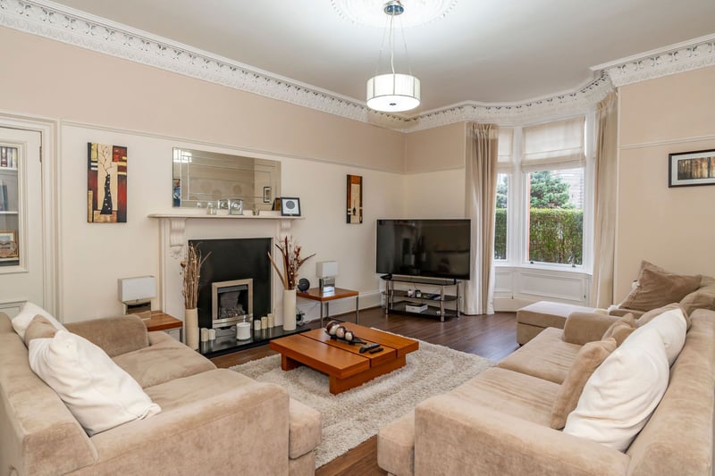 The bright and spacious sitting room with bay window, gas fire with an attractive surround, decorative cornicing and ceiling rose and a shelve display press.