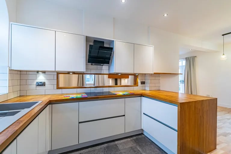 The kitchen has a range of fitted units and wood worktops.