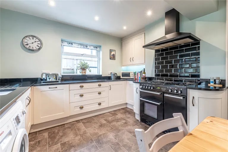 The kitchen features Shaker style base and wall units with granite worktops over.
