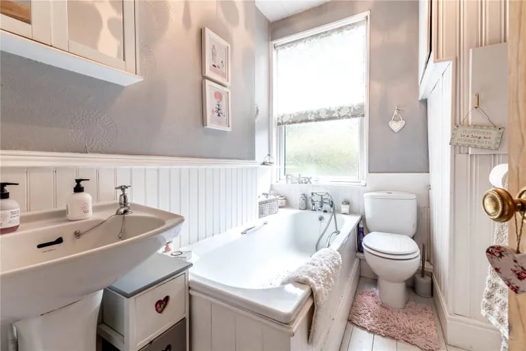 A three piece bathroom suite with stripped wooden flooring and built-in storage can also be found on the first floor .