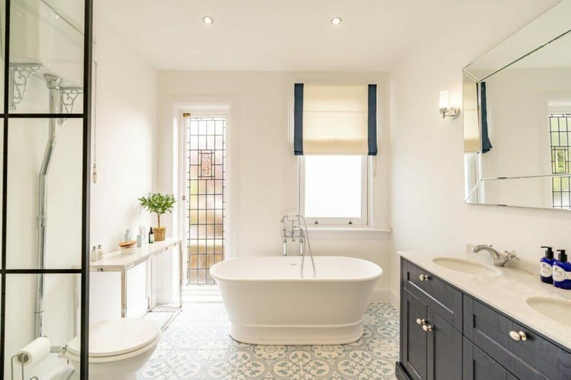 The stunning family bathroom has a full length lead window and beautiful free standing bath along with separate walk-in shower. 