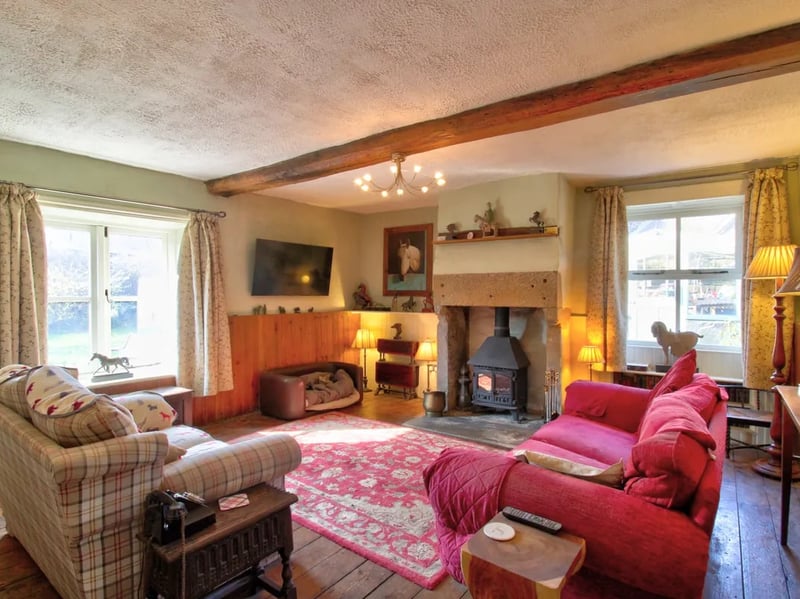The sitting room benefits from two large windows and a fireplace.
