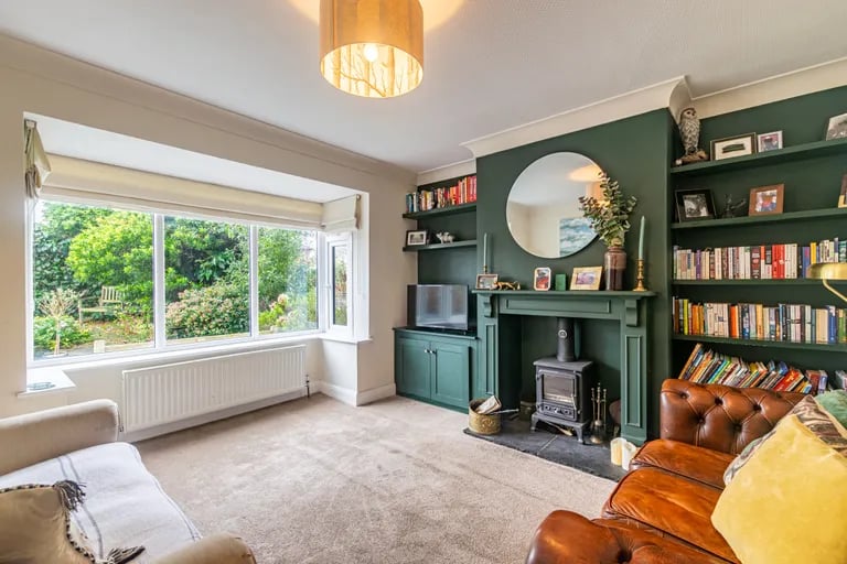 To the front is a well proportioned lounge with bay window, built in shelves and wood burning stove.
