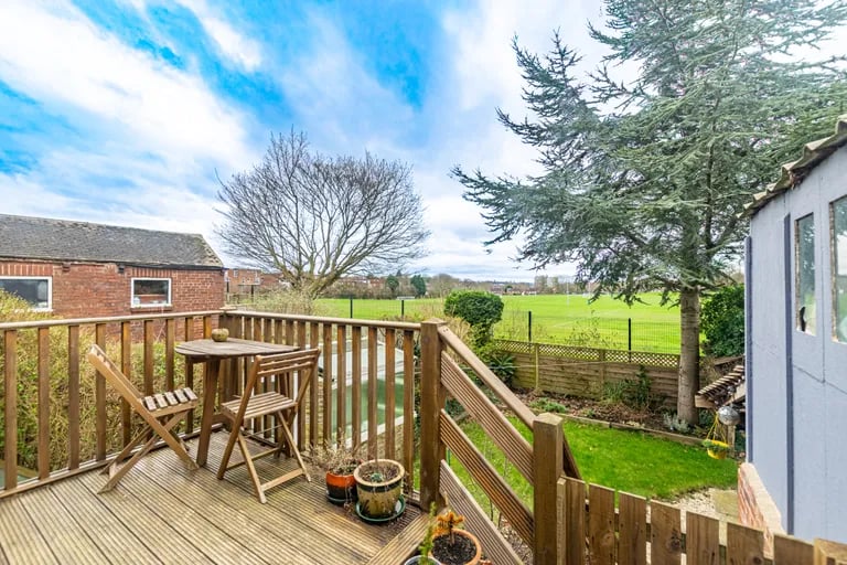 A decked terrace overlooks the garden and offers stunning views of the surroundings.