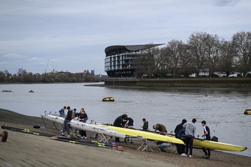 Rowers head out on the river as fans make their way through Bishops Park to the stadium.