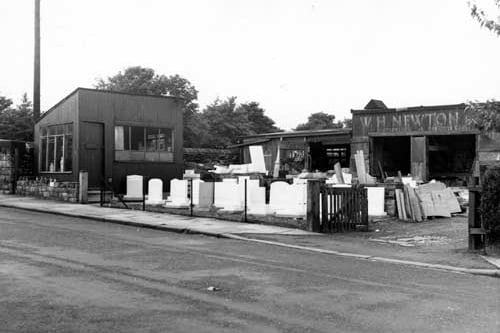 the workshop and office of W.H.Newton and Co. monumental masons on Middleton Road  in July 1967. This yard is filled with finished headstones and blocks of stone waiting for use. Beneath the name of the company over the workshop door is written 'Memories of Distinction'. The proprietor at this time was W.E.Cresswell.