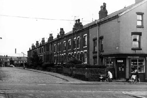 In the foreground of this view Parnaby Road can be seen. The odd numbered side of Westbury Place runs from the left in ascending order to number 55 on the right. This house is next to a small grocers at number 35 Parnaby Road, business of M.Dent. Two ladies with pushchairs walk along the pavement. In the background, on the left edge, are several properties on the even numbered side of Westbury Place, visible as the road curves round. Pictured in July 1967.