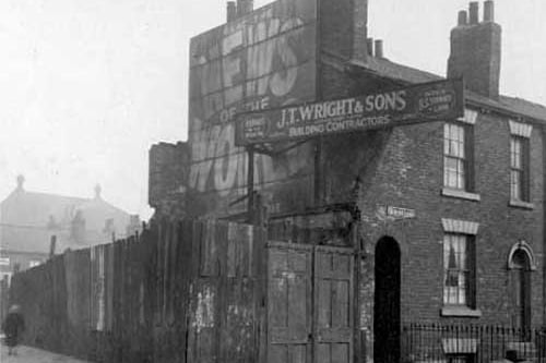 The junction of Skinner lane with Cross Stamford Street. Building on corner has been demolished and workmens barriers surround the area. Signs on gable end of remaining property states 'Read the News of the World', 'J.T. Wright & Sons established 1845 Building Contractor'. Pictured in April 1928.
