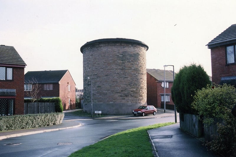 The Morley Tunnel Ventilation Shaft on the Hopewell Farm estate. One of four ventilation shafts serving the tunnel, it had originally stood alone in a field on Hopewell Farm, but is now in the middle of a modern housing estate. The main road in the picture is Alden Avenue, with Alden Close leading off by the side of the shaft.  Pictured in December 1994.
