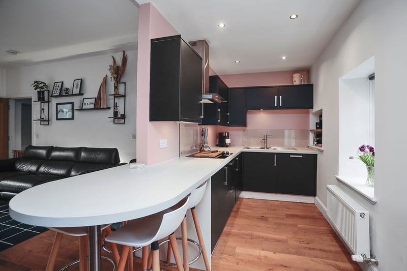 The open plan quality fitted kitchen area with integrated appliances and breakfast bar.   The property sale includes the integrated white goods (fridge/freezer, oven, hob, microwave, washing machine and dishwasher) curtains, blinds, wardrobe in bedroom 2 and garden shed.