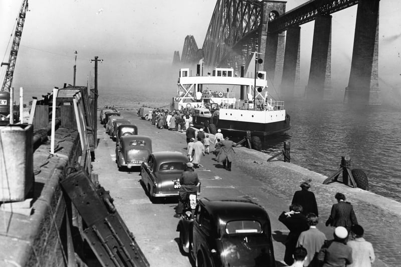 Cars queue up at South Queensferry in the shadow of the Forth Bridge to board the ferry across the Forth in 1956.
