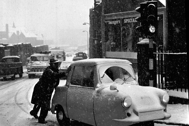 A three-wheeler needs a push up Holyrood Road in Edinburgh during the snow showers of February 1969.