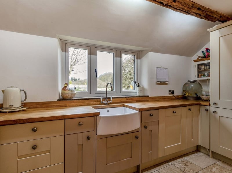 The wooden finish of the kitchen fits brilliantly with the exposed beams of this charming cottage.