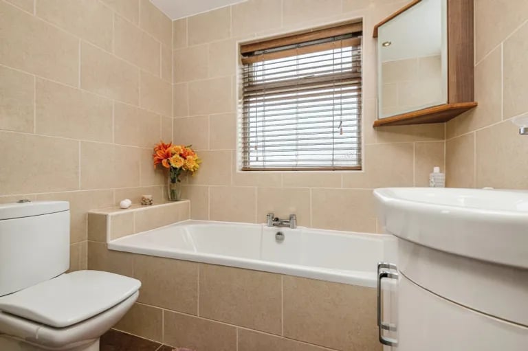 The modern bathroom features elegant finishes and a bath and separate shower.