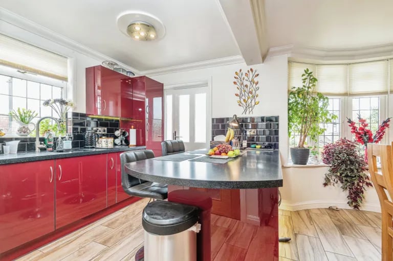 The modern burgundy kitchen features sleek countertops and contemporary appliances.