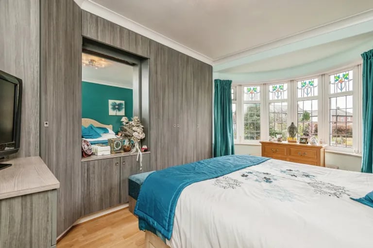 On the first floor are three unique bedrooms. This one features built-in wardrobes and a bay window to the front elevation.