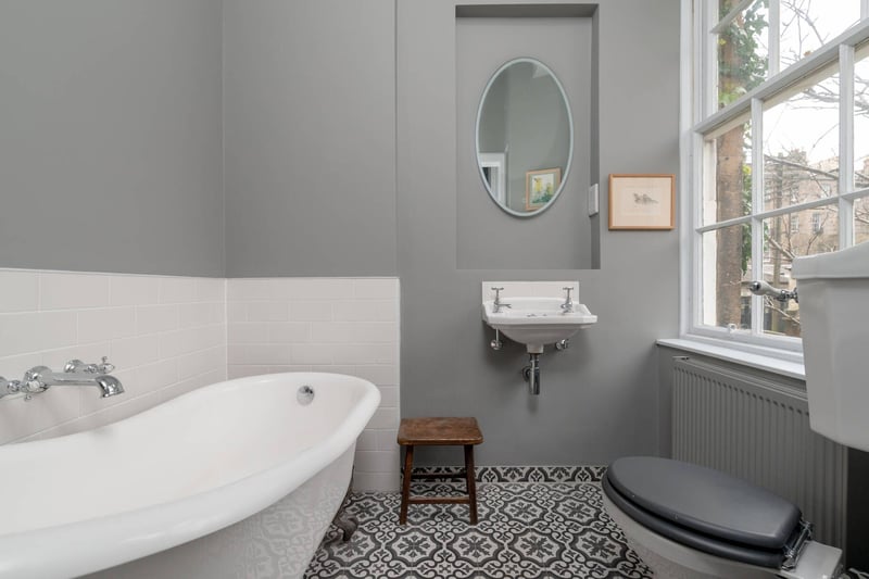 The en-suite bathroom, featuring a white three-piece suite comprising a free-standing claw-foot bath, WC and wash hand basin.