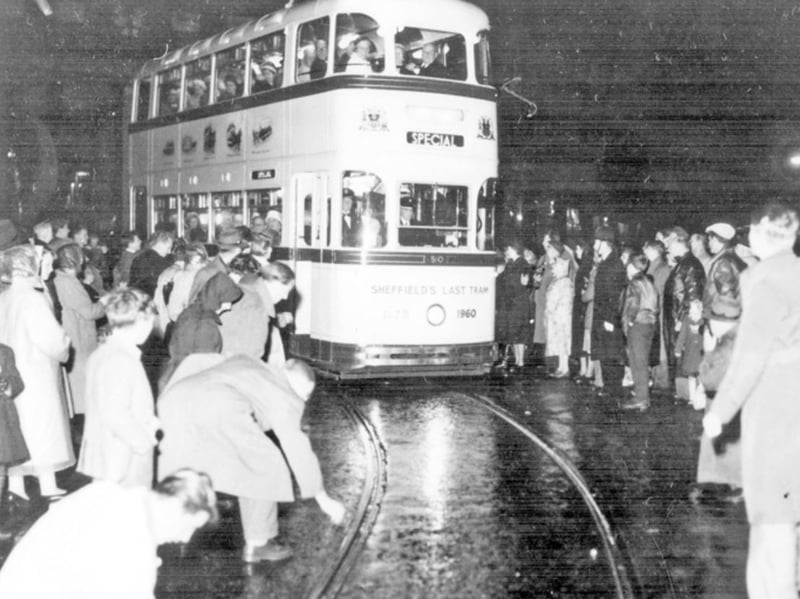 Coins being placed on the tram track as the last tram procession passes through Sheffield city centre in October 1960