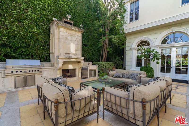 The Beverly Hills mansion also has a very large backyard that accommodates an outdoor dining area, large BBQ and fireplace (Credit: The MLS)