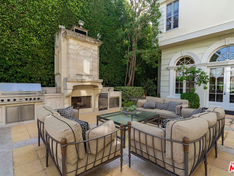 The Beverly Hills mansion also has a very large backyard that accommodates an outdoor dining area, large BBQ and fireplace (Credit: The MLS)