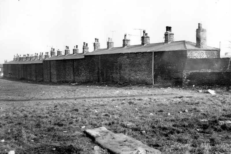 A view looking over open land on Ley Lane onto the blind backs of houses on Prospect Grove. A mattress can be seen in the foreground. Pictured in March 1964.
