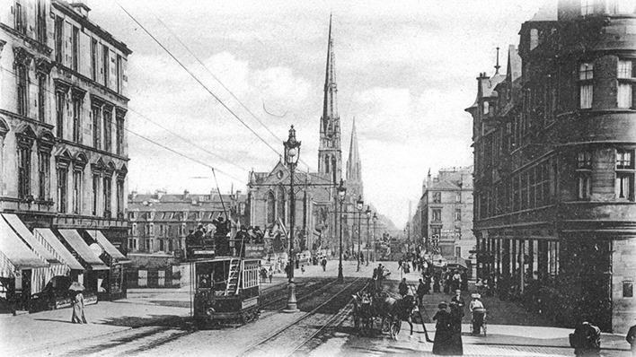 Glaswegians going about their business on Great Western Road along the Kelvin Bridge. The beautiful Lansdowne Church, built in 1863, dominates the background. 