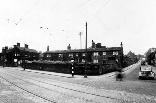The junction of Abbey Road and Kirkstall Lane, showing tram lines, traffic lights, bus, car, overhead tram wires, Abbey Cinema, Cross Row. Pictured in  July 1938.