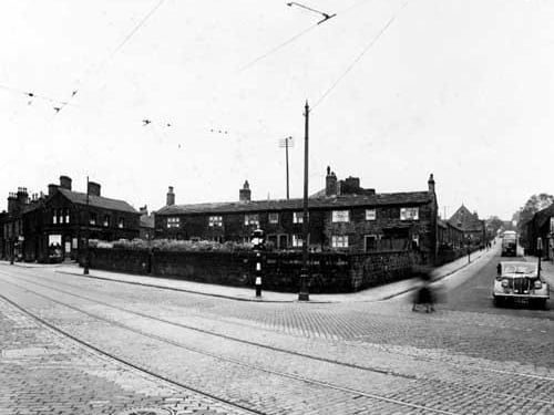 The junction of Abbey Road and Kirkstall Lane, showing tram lines, traffic lights, bus, car, overhead tram wires, Abbey Cinema, Cross Row. Pictured in  July 1938.
