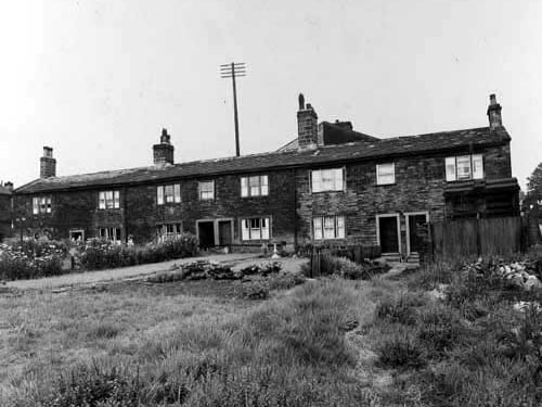 A row of stone cottages at the junction of Abbey Road and Kirkstall Lane in July 1938. Gardens in view, including a vegetable patch and a bird bath in one.