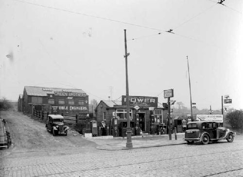 Green Brothers motor engineers on Commercial Road. Shows petrol kiosk with pumps to front and workshops accessible via mud track. Pictured in April 1937.