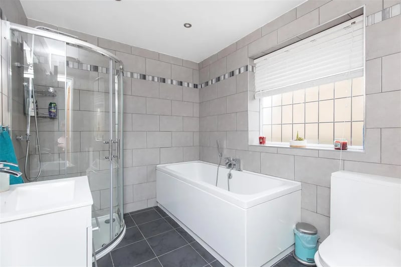 The tiled family bathroom features both a bathtub and a spacious shower.