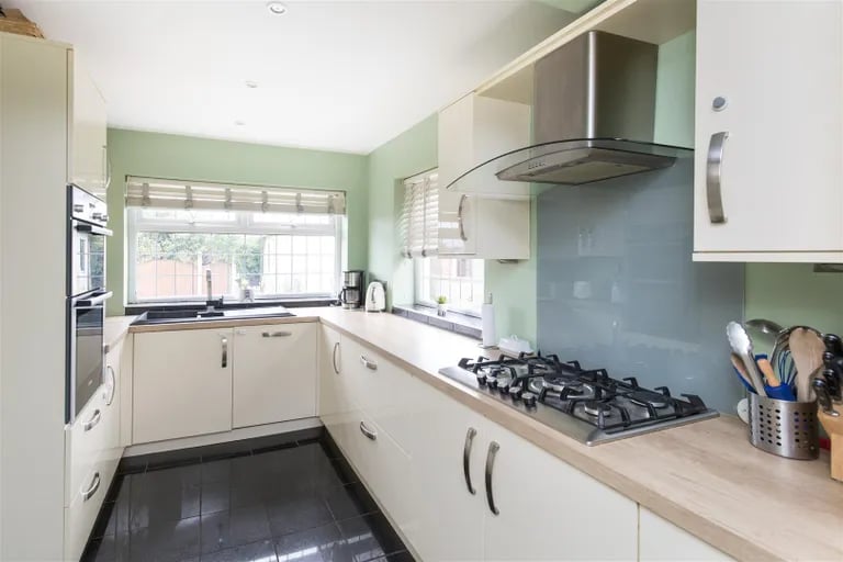 The well equipped kitchen with a range of fitted matching base and eye-level wall units.