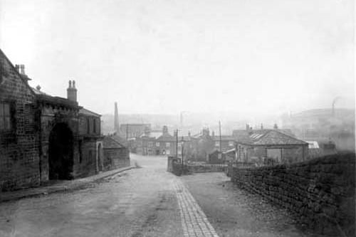 Looking towards Wyther Lane showing the canal bridge. This photograph was taken prior to the construction of a new bridge. On the left is a building with an archway and an arched porch, and on the right is what is possibly a workshop or small factory. Straight ahead there are premises on Wyther Lane including the Bridge Inn. Pictured in November 1930.