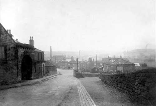 Looking towards Wyther Lane showing the canal bridge. This photograph was taken prior to the construction of a new bridge. On the left is a building with an archway and an arched porch, and on the right is what is possibly a workshop or small factory. Straight ahead there are premises on Wyther Lane including the Bridge Inn. Pictured in November 1930.