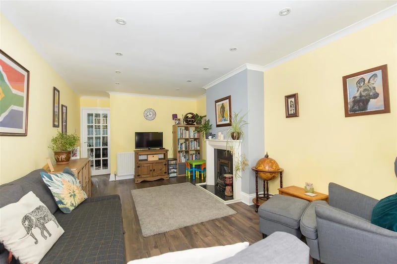 The living room is a large welcoming space with laminate flooring.