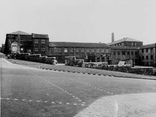 Improvements to wall and factory at junction of Kirkstall Hill. Tubex Silencer Co can be seen through gateway in stone wall. Thomas Waide and Sons, Printer to left of photo. Also in view is a belisha beacon and a woman and child pushing a pram. Pictured in July 1938.