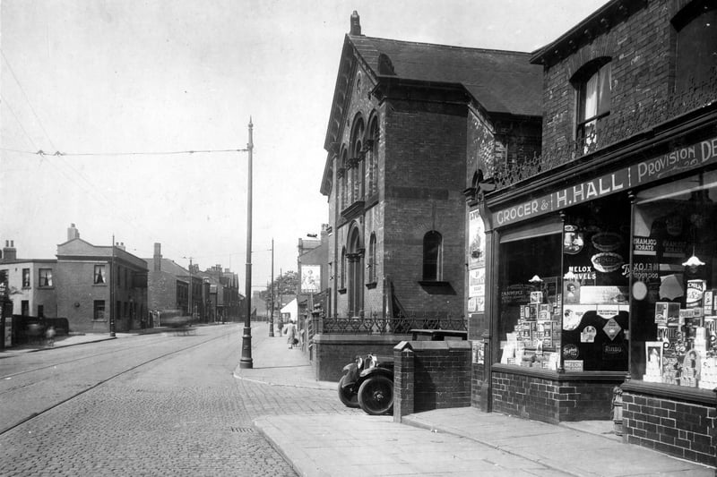 Town Street in July 1929. On the left can be seen the White Hart yard, next is the old White Hart Inn, Landlord William Henry Louth. A hanging sign can be seen over the pub doorway. To the right is the Wesleyan Chapel, next the junction with Wesley Street. A car is partially in view. Nos.2/4, is a grocers shop run by Harry Hall. 