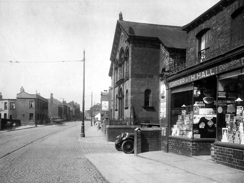 Town Street in July 1929. On the left can be seen the White Hart yard, next is the old White Hart Inn, Landlord William Henry Louth. A hanging sign can be seen over the pub doorway. To the right is the Wesleyan Chapel, next the junction with Wesley Street. A car is partially in view. Nos.2/4, is a grocers shop run by Harry Hall.